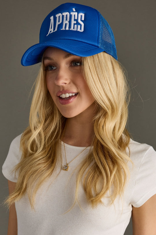 Woman wearing a blue cap with 'APRèS' text on a gray background