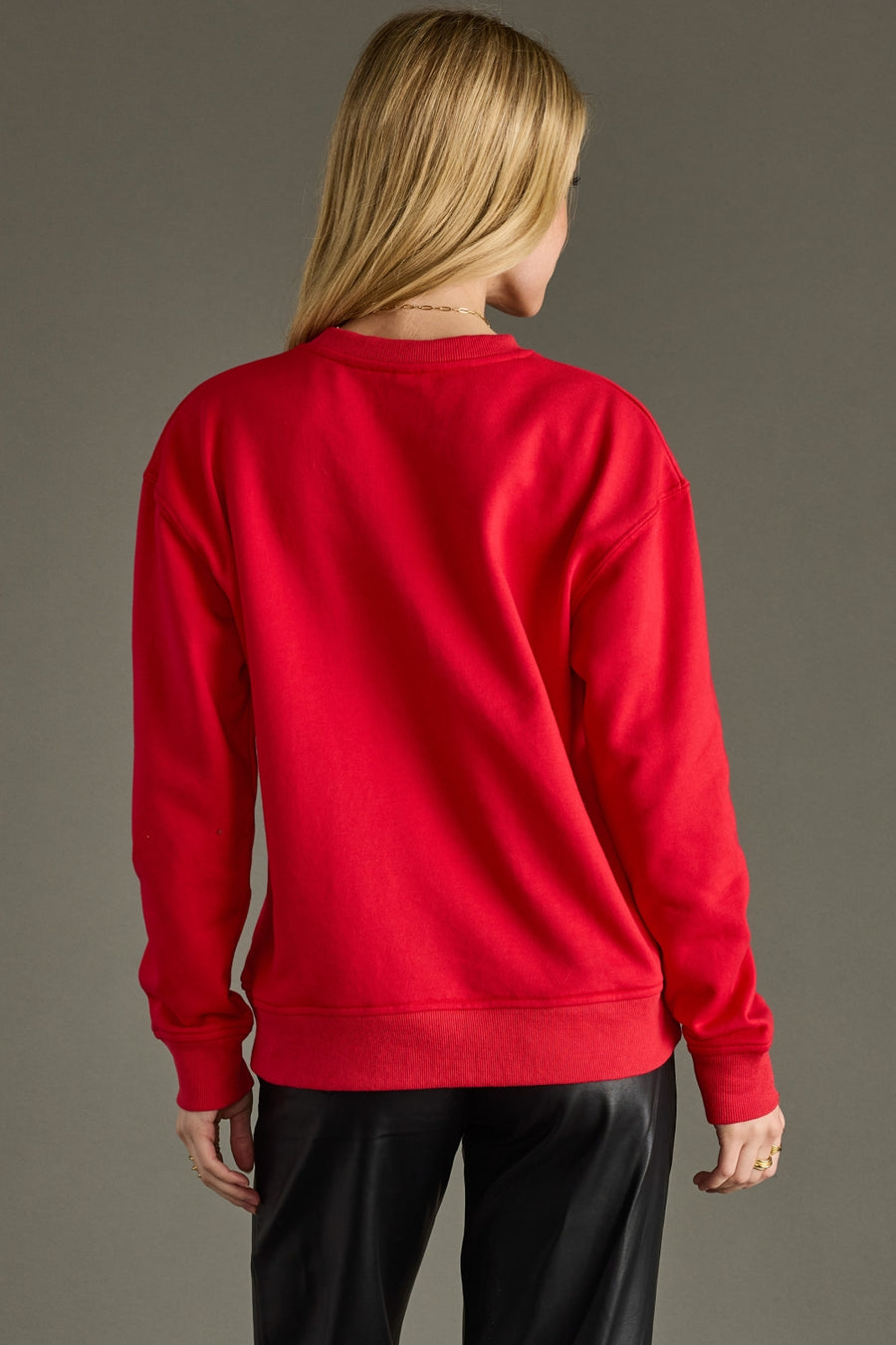 Person wearing a red sweatshirt on a gray background