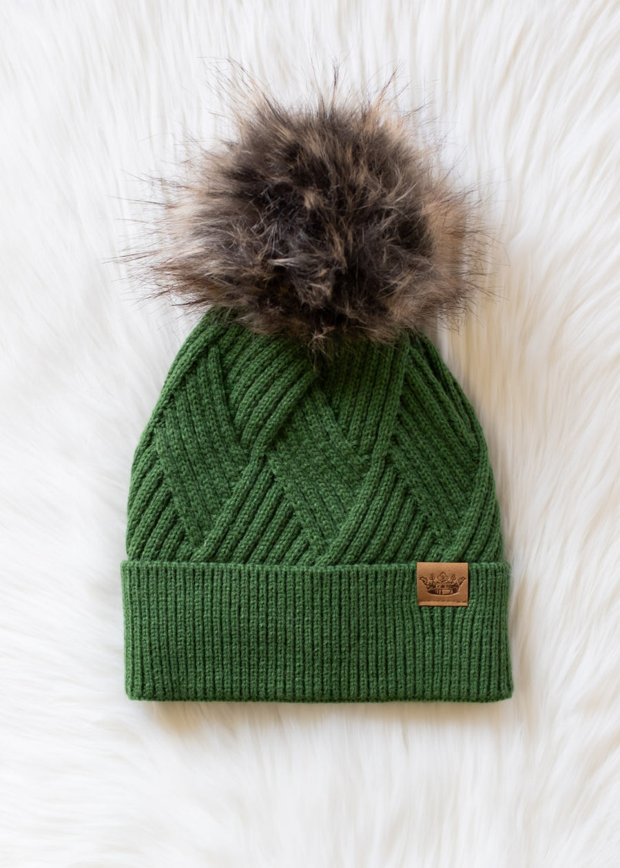 Green knit beanie with fur pom-pom on a white background