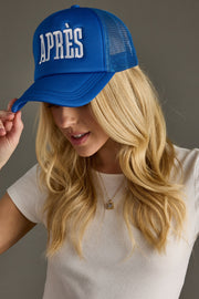 Woman wearing a blue cap with 'APRèS' text on a gray background