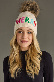 Person wearing a beanie with 'MERRY' in colorful letters on a plain background