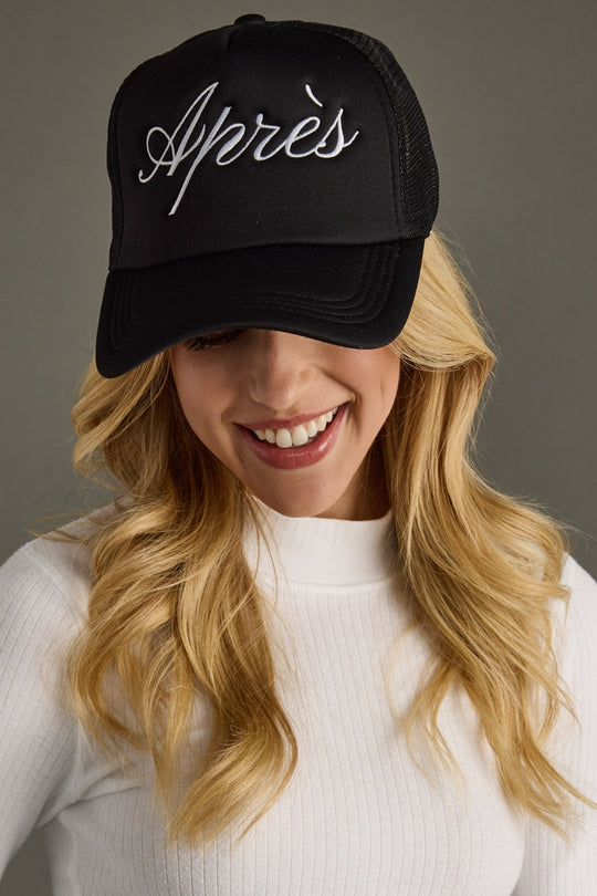 Person wearing a black cap with 'Apres' text on a gray background