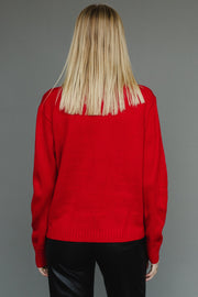 Person wearing a red sweater with a plain gray background