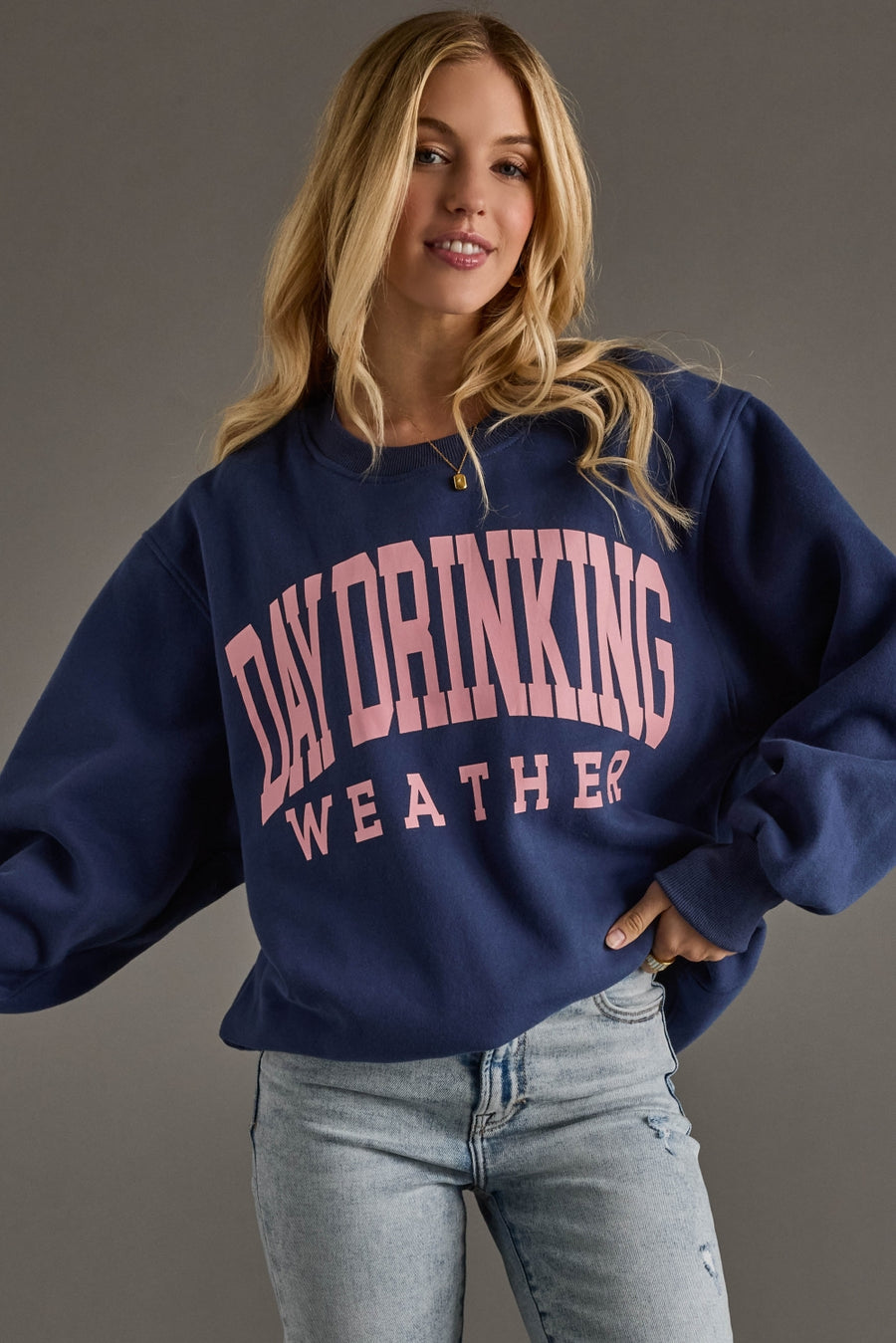 Person wearing a navy blue sweatshirt with 'Day Drinking Weather' text on a gray background