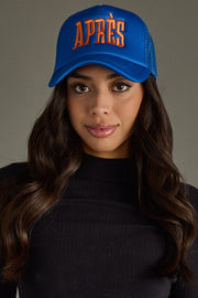 Woman wearing a blue cap with 'APRèS' text on a gray background