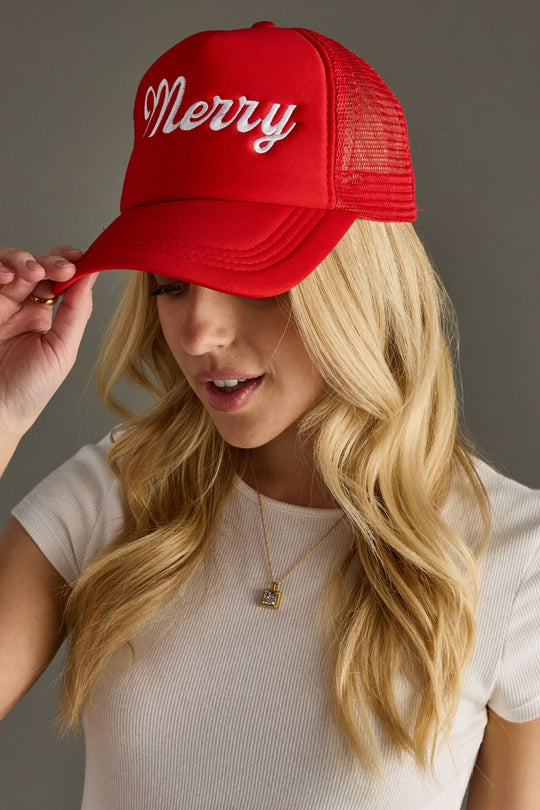Woman wearing a red cap with 'Merry' text on a gray background