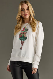 A woman with long blonde hair models the Panache Apparel Collection Perfect Gift Sweatshirt—a relaxed fit, lightweight top with a girl-with-presents graphic—paired with black leather pants against a plain gray background.