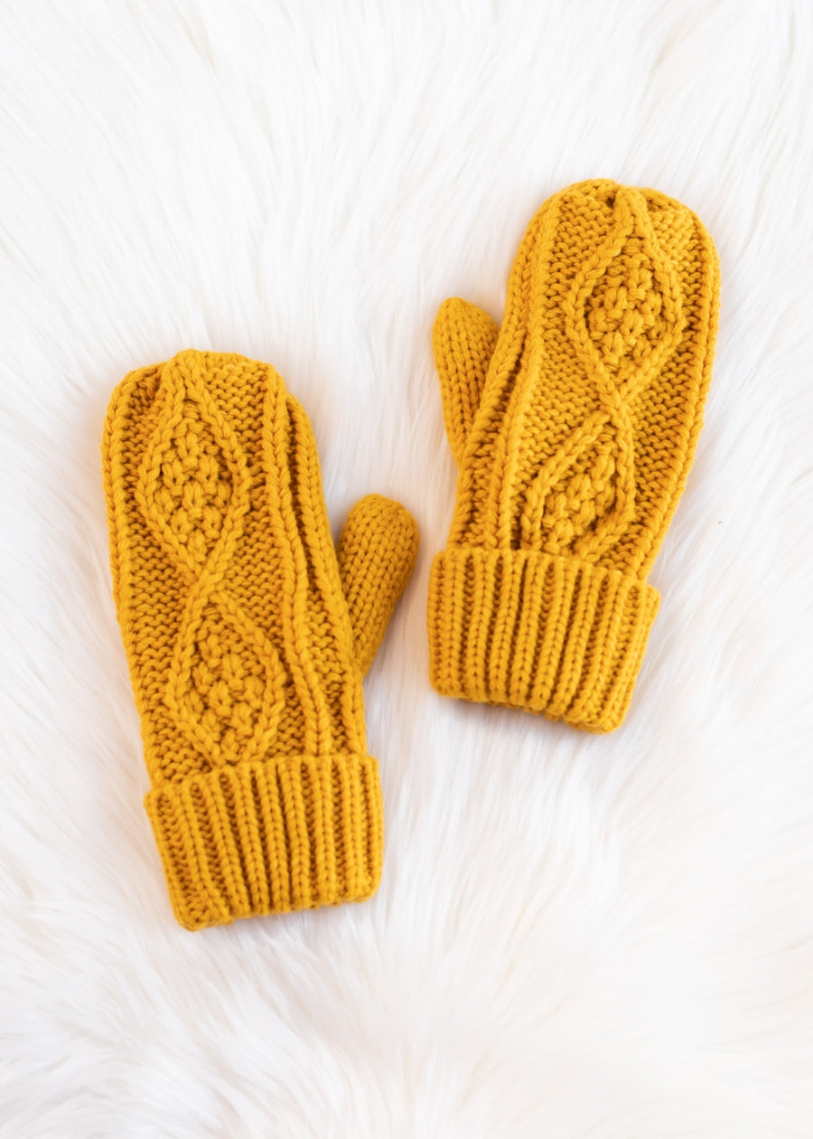 Pair of mustard yellow knitted mittens on a white background