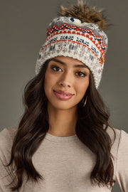 Woman wearing a patterned knit beanie against a gray background