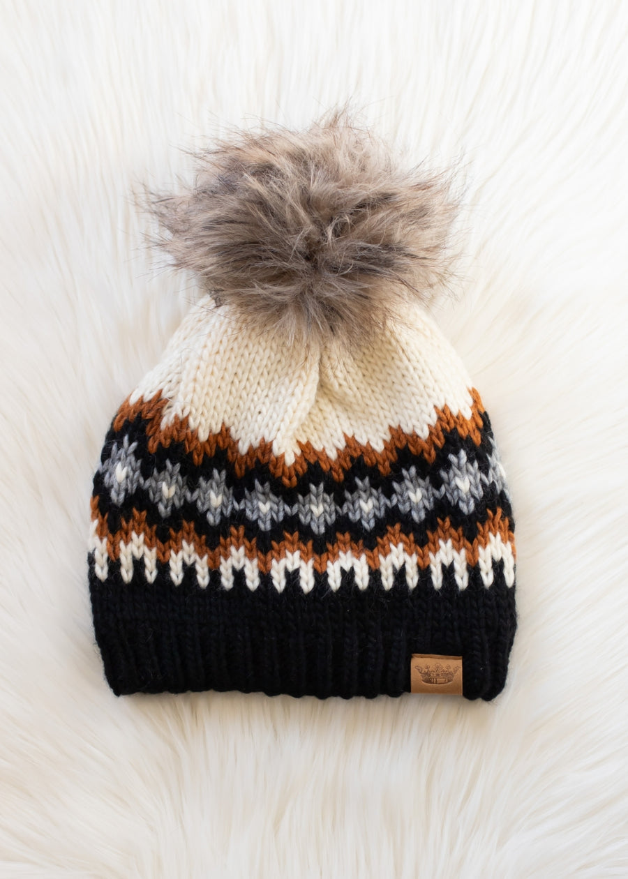 Knitted beanie with a pom-pom on a white background