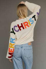 Ivory knit sweater with multicolored 'Merry Christmas' text on the back
