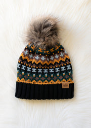 Knitted beanie with a patterned design and fur pom-pom on a white background