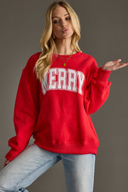 Person wearing a red sweatshirt with 'MERRY' printed on it against a gray background