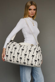 Woman holding a white bag with black patterns against a gray background