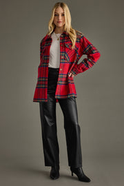 Woman wearing a red plaid jacket with a plain background