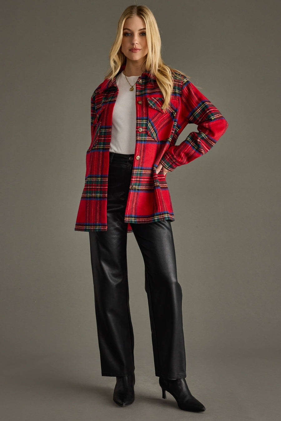Woman wearing a red plaid jacket with a plain background