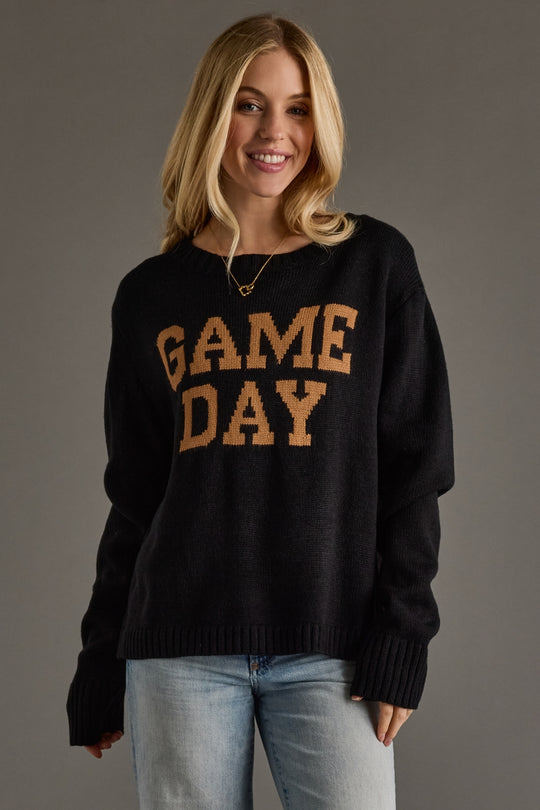 Woman wearing a black sweater with 'GAME DAY' text on a gray background