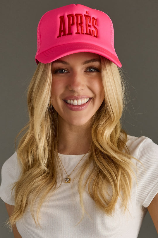 Woman wearing a pink cap with 'APRèS' text on a gray background