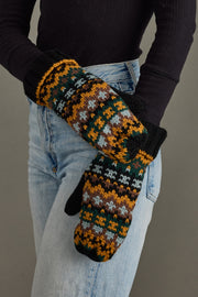 Person wearing patterned mittens with a plain background
