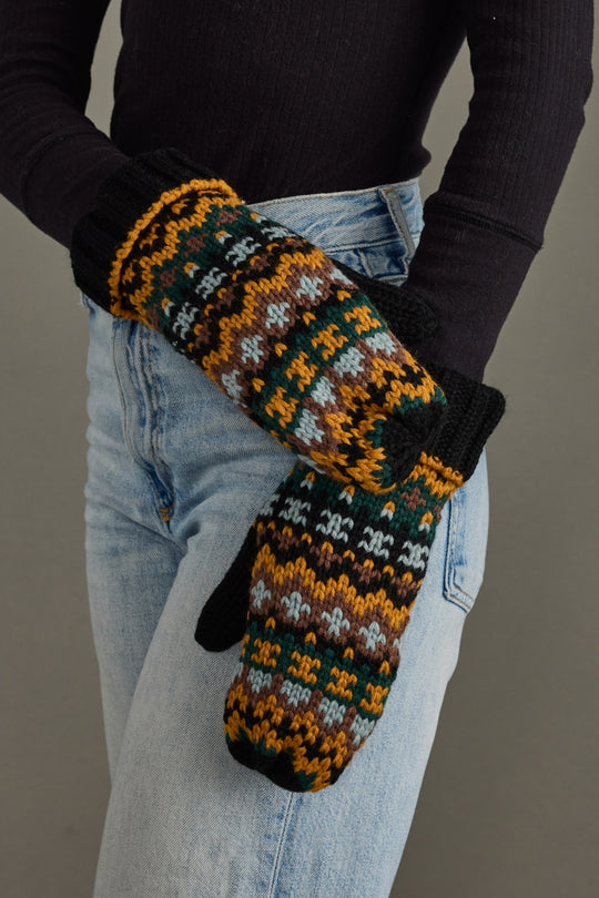 Person wearing patterned mittens with a plain background