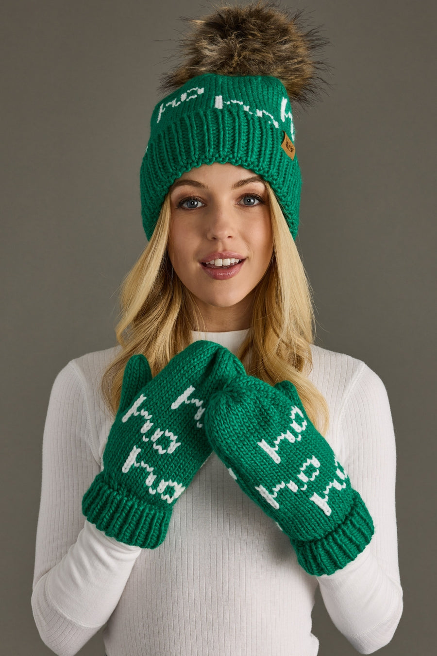 Person wearing a green knit hat and mittens with text on a gray background