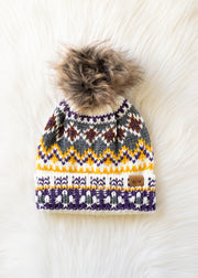Knit sweater with a pattern and fluffy pom-pom on a textured white background
