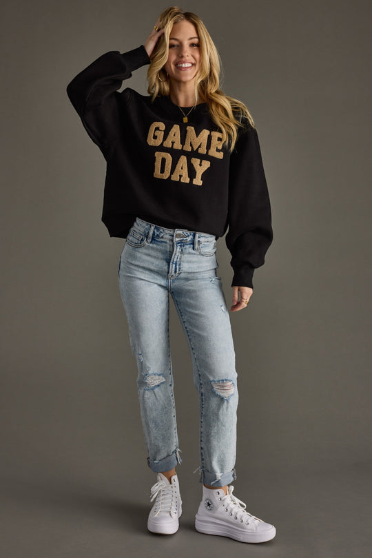 A black sweatshirt with bold gold chenille “GAME DAY” lettering — classic, cozy, and made for cheering in style.
