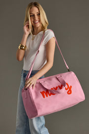 Woman holding a pink duffel bag with orange text against a gray background