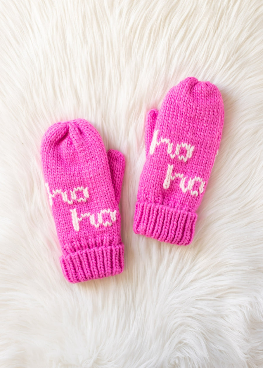 Pair of pink mittens with 'ho ho ho' text on a white fur background