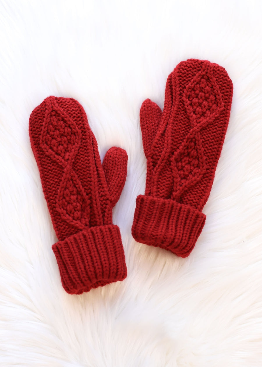 Pair of red knitted mittens on a white background
