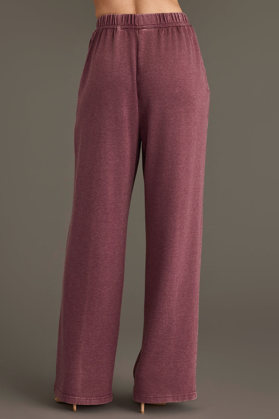 A person is shown from the waist down and viewed from the back, wearing Panache Apparel Collection’s Merlot Washed Soft Sweatpants. A loose-fitting, high-waisted style, in front of a plain gray background.
