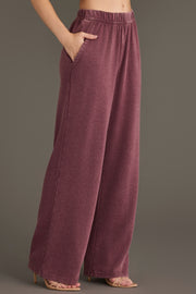 A person models the Panache Apparel Collection Merlot Washed Soft Sweatpants. It is a loose, wide-leg maroon sweatpants with hands in pockets, paired with beige heeled sandals against a neutral background, showing only the lower body.