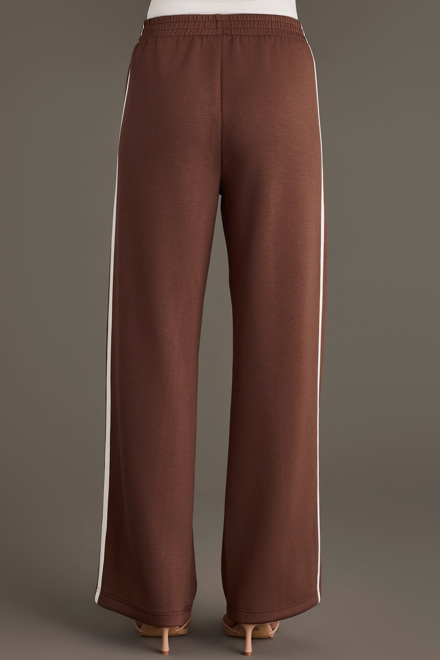 Back view of Brown Lounge Sweatpants in brown with a wide-leg fit and a white vertical stripe along each side.