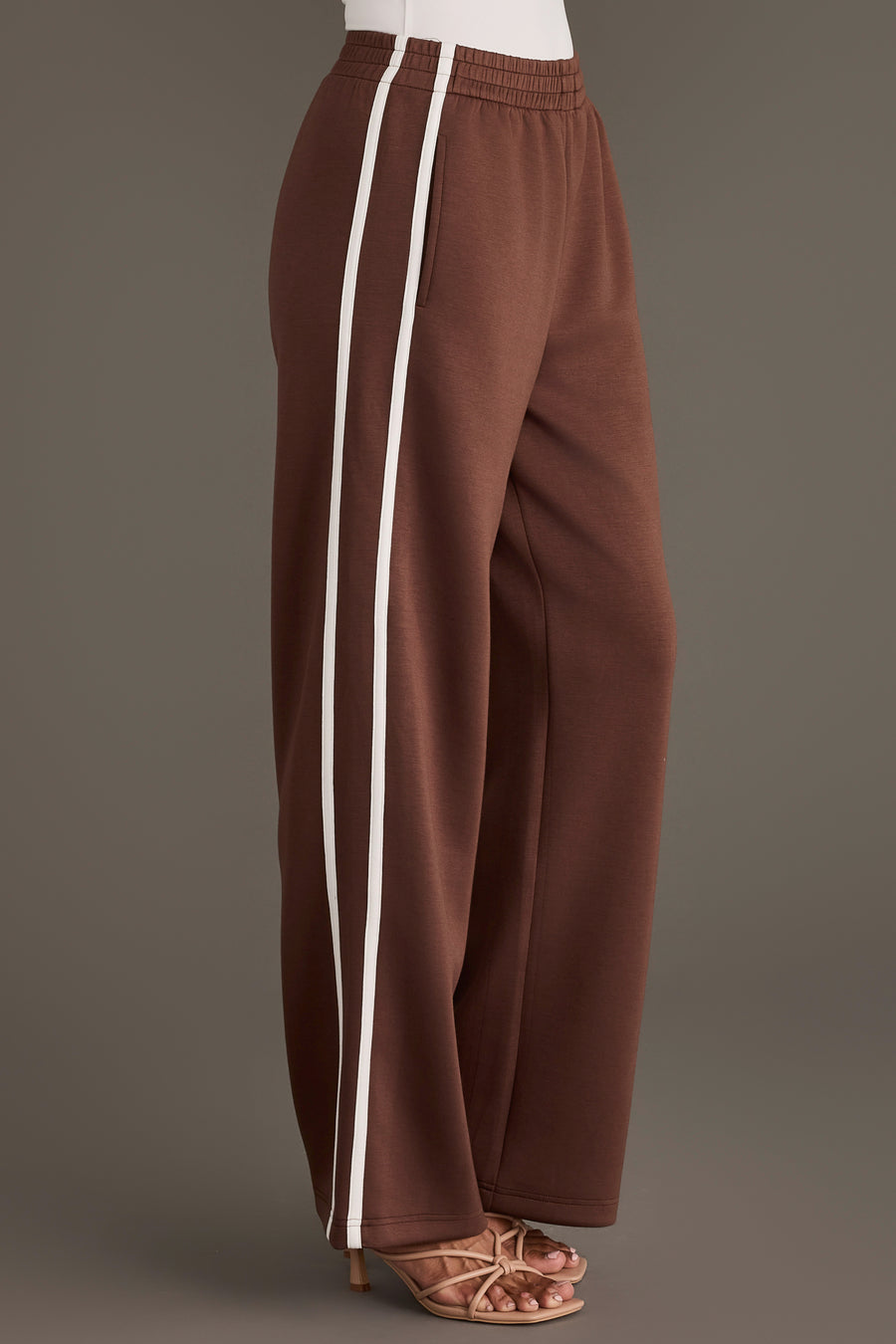 Brown Lounge Sweatpants featuring a wide-leg fit, two white vertical side stripes, and an elastic waistband.
