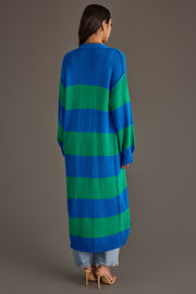 A person stands facing away against a plain background, wearing the Panache Apparel Collection’s Royal Blue & Green Striped Duster Cardigan, paired with light blue jeans and beige high-heeled sandals.