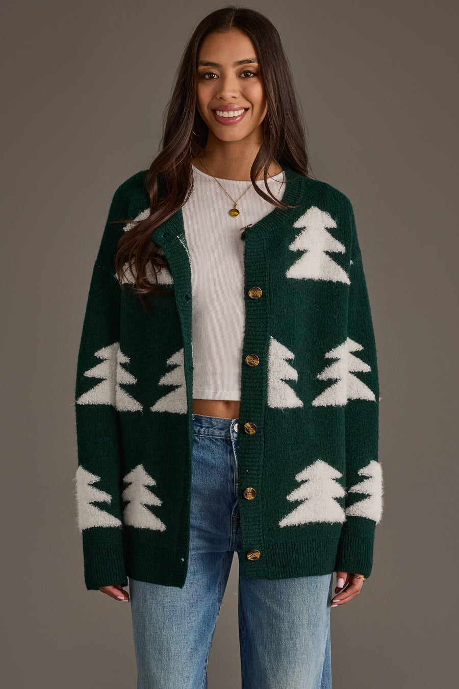Woman wearing a Green Button Up Tree Cardigan from the Panache Apparel Collection over a white crop top and blue jeans.