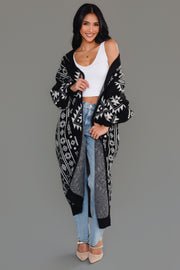 Woman styling Panache Apparel’s black and white Western cardigan off the shoulder over a white crop top and jeans.