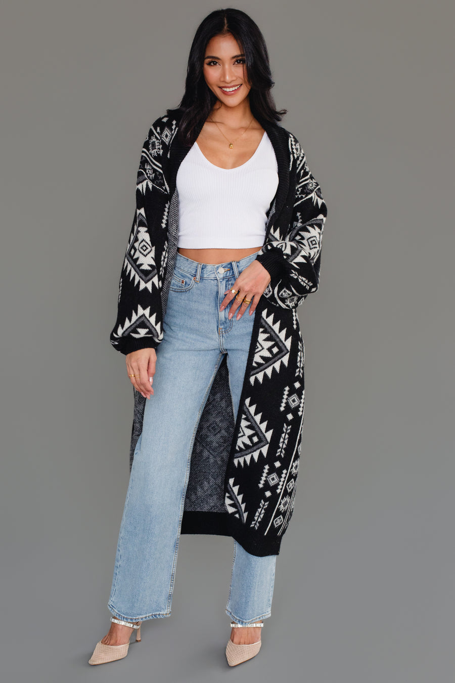Full-length model wearing Panache Apparel’s black and white Western cardigan with light wash jeans and neutral heels.