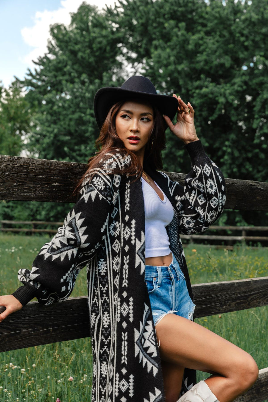 Outdoor close-up of a woman wearing Panache Apparel’s black and white Western cardigan with bold geometric knit detailing.