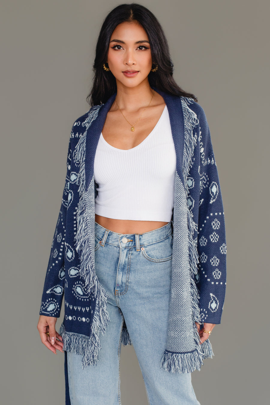Woman wearing Panache Apparel’s blue bandana fringe cardigan open over a white tank, front view.