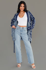 Full-body studio image of Panache Apparel’s blue bandana fringe cardigan worn open with light wash jeans.