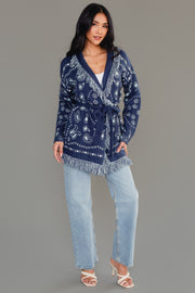 Full-length studio view of Panache Apparel’s blue bandana fringe cardigan with bandana print and fringe detail.