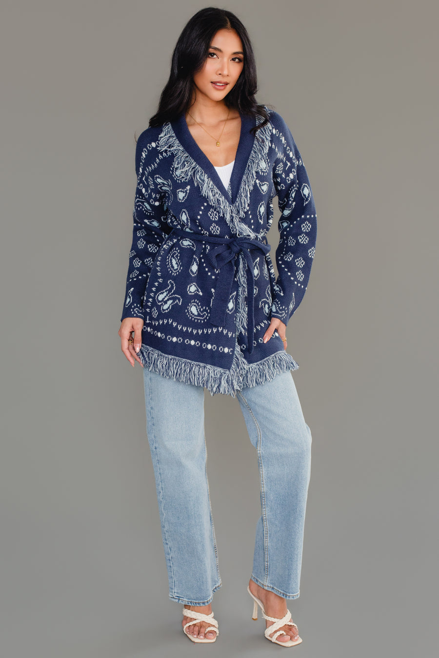 Full-length studio view of Panache Apparel’s blue bandana fringe cardigan with bandana print and fringe detail.