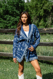 Woman wearing Panache Apparel’s blue bandana fringe cardigan outdoors, front view.