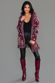 Woman wearing Panache Apparel’s burgundy bandana fringe cardigan open over a black bodysuit, front view.