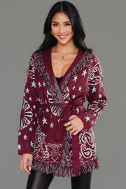 Front studio shot of Panache Apparel’s burgundy bandana fringe cardigan with fringe trim and tie belt.