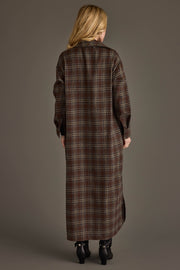 A person stands facing away, wearing the Panache Apparel Collection’s Brown, Cream & Blue Plaid Long Lightweight Jacket. The background is plain and neutral.