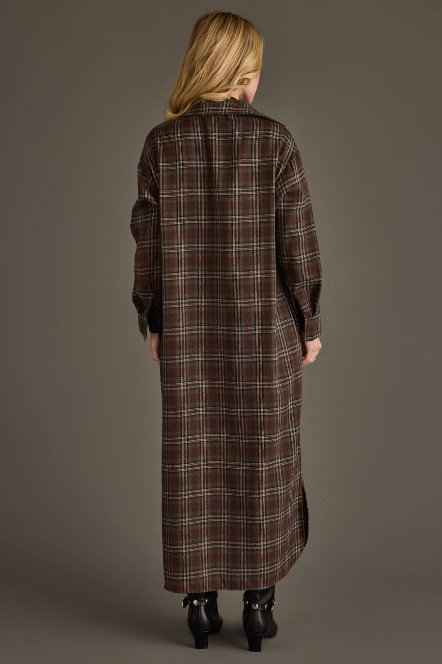 A person stands facing away, wearing the Panache Apparel Collection’s Brown, Cream & Blue Plaid Long Lightweight Jacket. The background is plain and neutral.