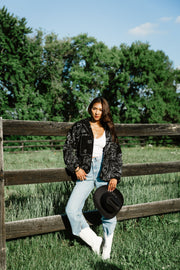 Woman styling Panache Apparel’s black and white paisley fleece coatigan outdoors with a western-inspired outfit.