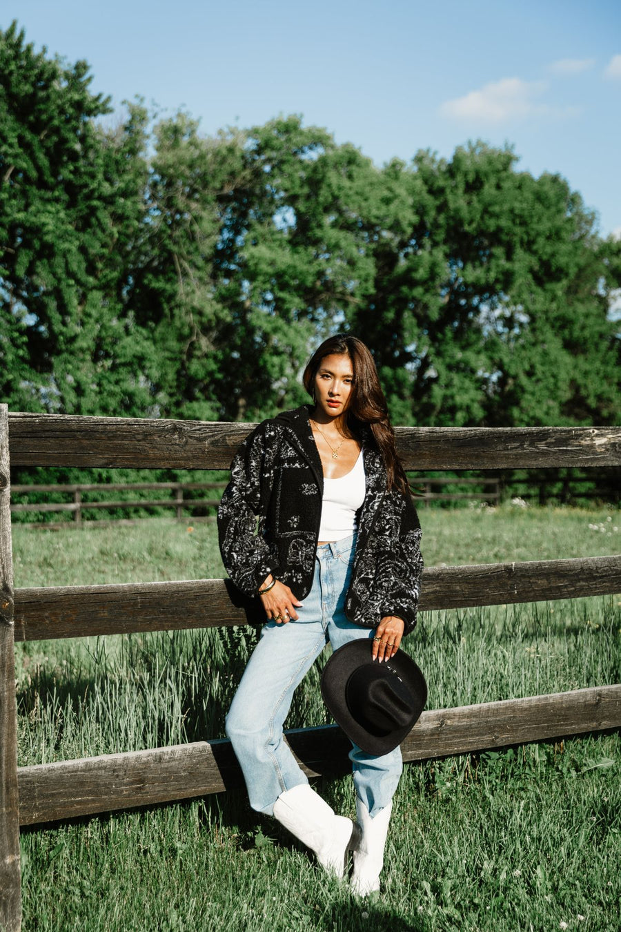 Woman styling Panache Apparel’s black and white paisley fleece coatigan outdoors with a western-inspired outfit.